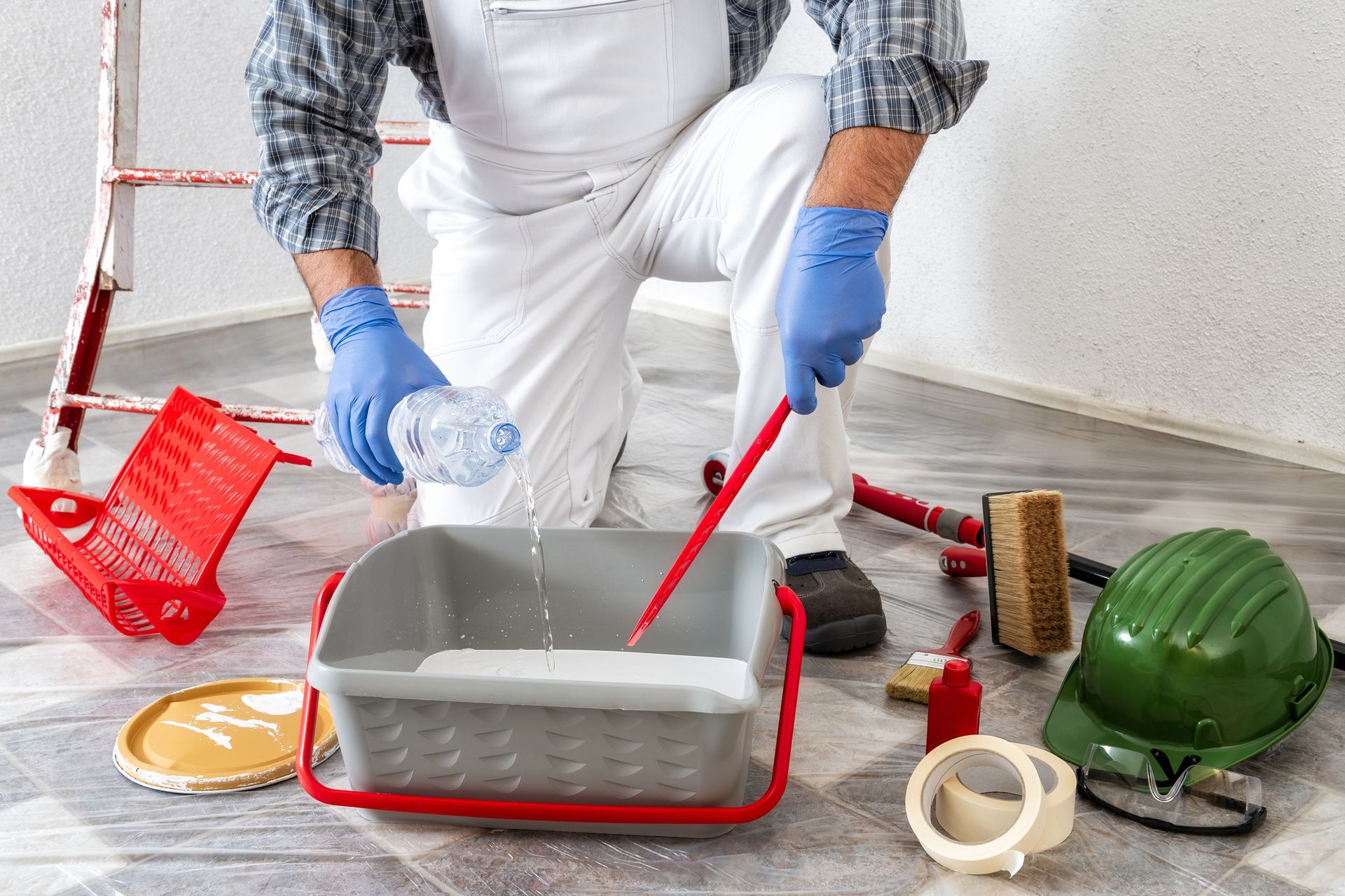 A man is pouring paint into a paint roller.