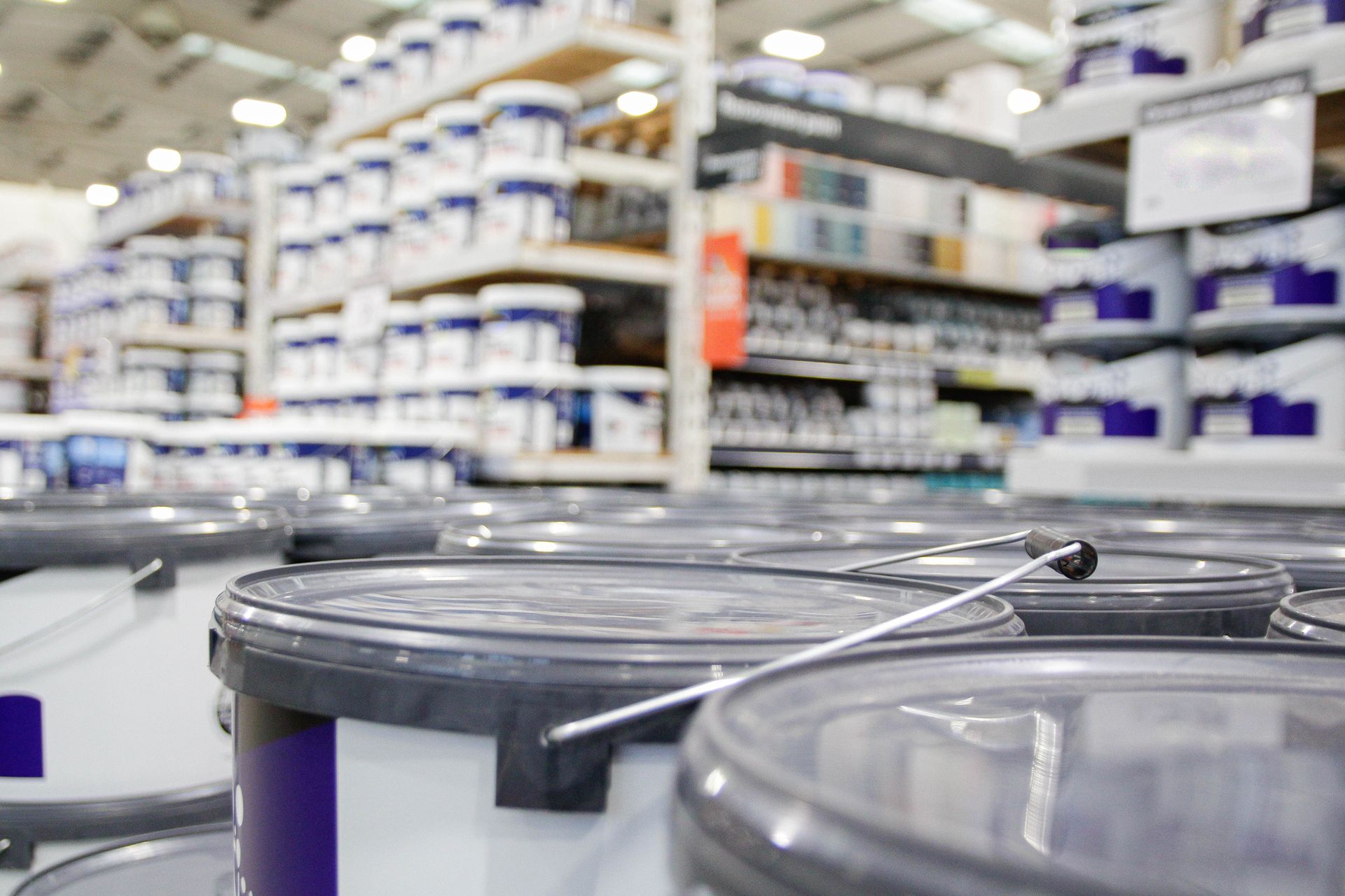 A vibrant paint supply store filled with colorful paint cans arranged on shelves and displays.