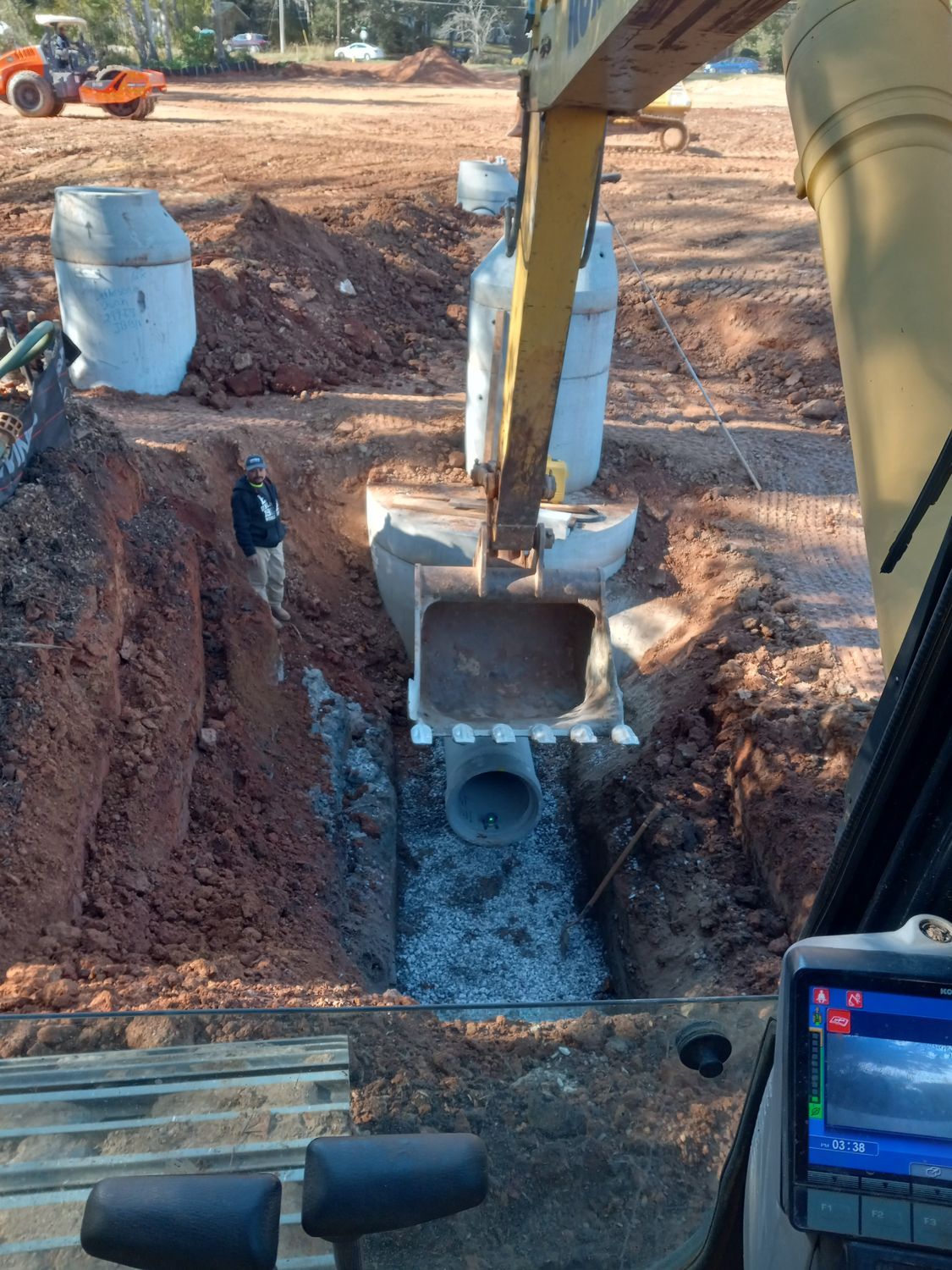 A yellow excavator is digging a hole in the ground