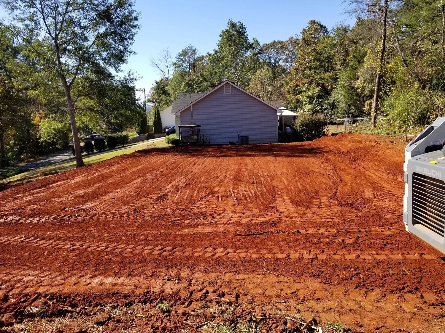 A house is sitting in the middle of a dirt field.