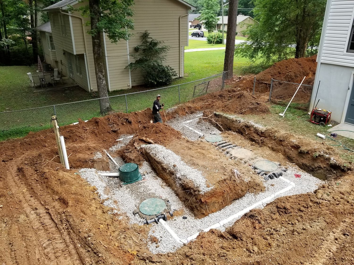 An aerial view of a septic system being installed in a backyard.