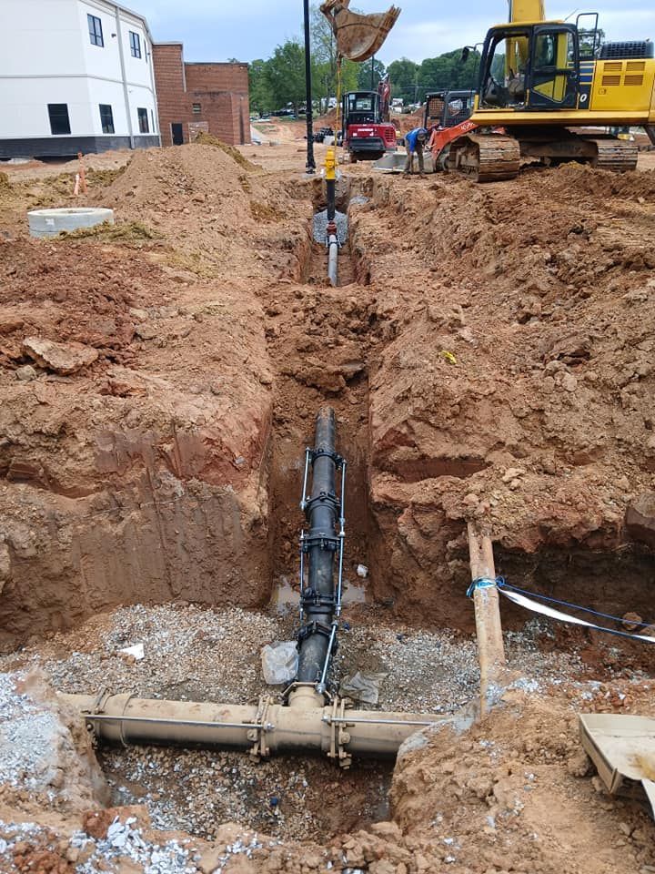 A pipe is being installed in a hole in the ground.