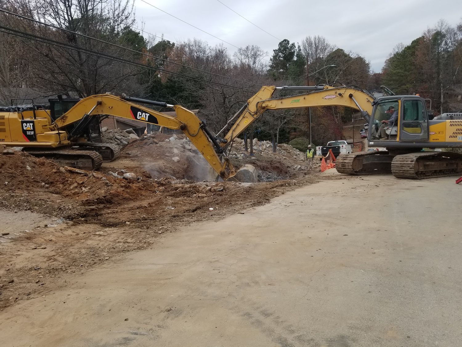 A couple of excavators are working on a construction site.