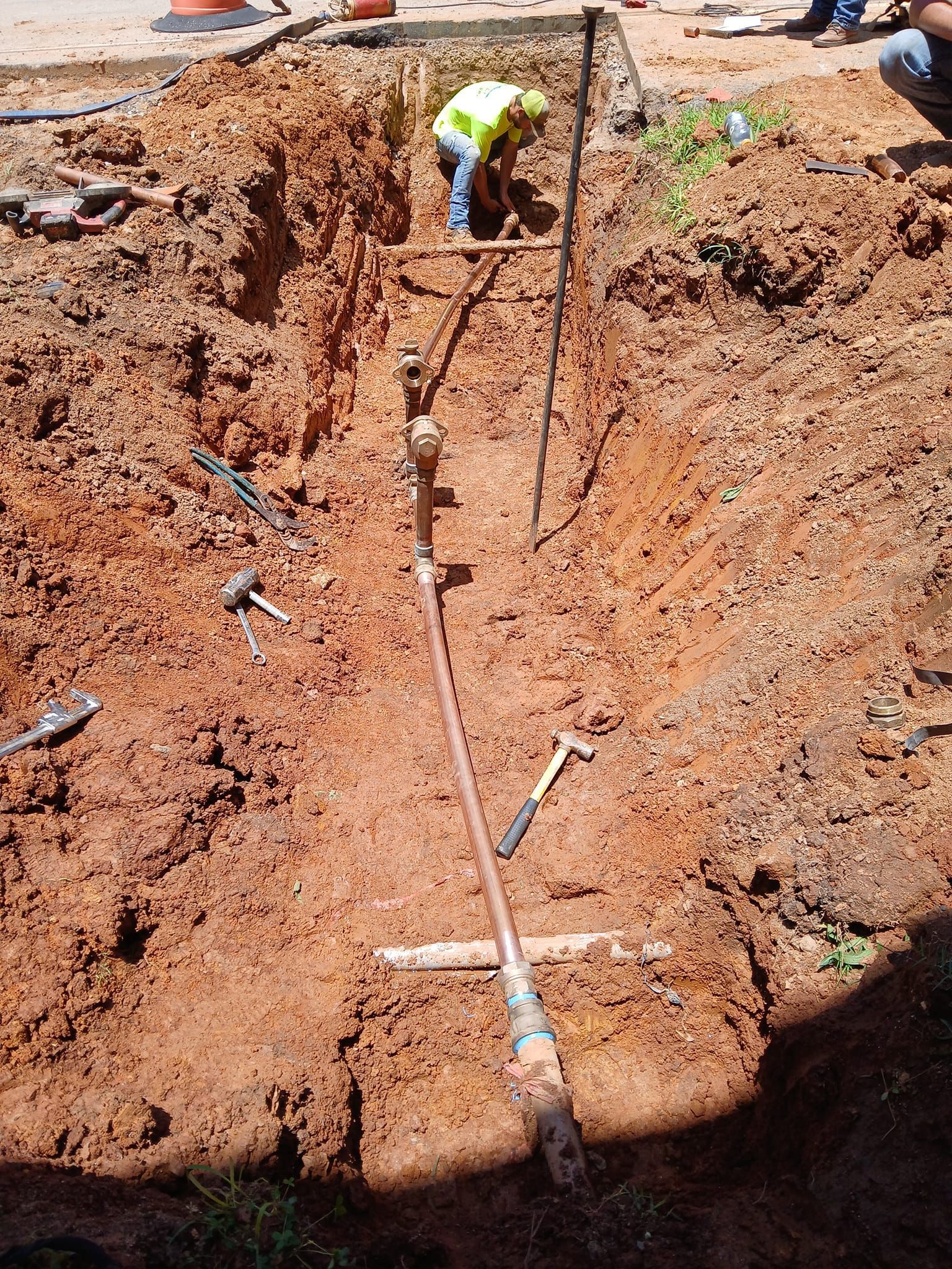 A construction worker is digging a hole in the dirt.