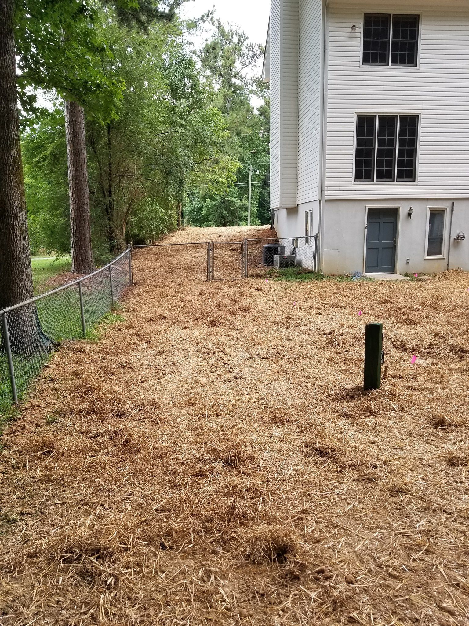A house with a lot of wood chips in front of it.