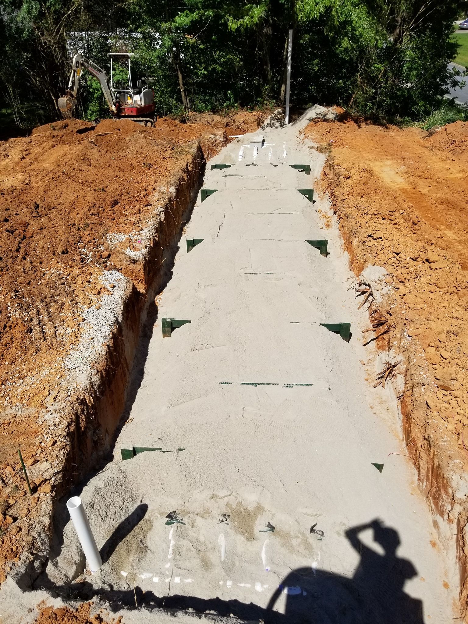 A drainage system is being built in a dirt field.