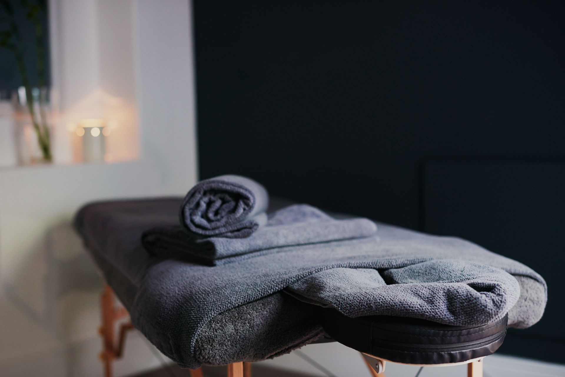 A massage table with towels on it in a dark room.