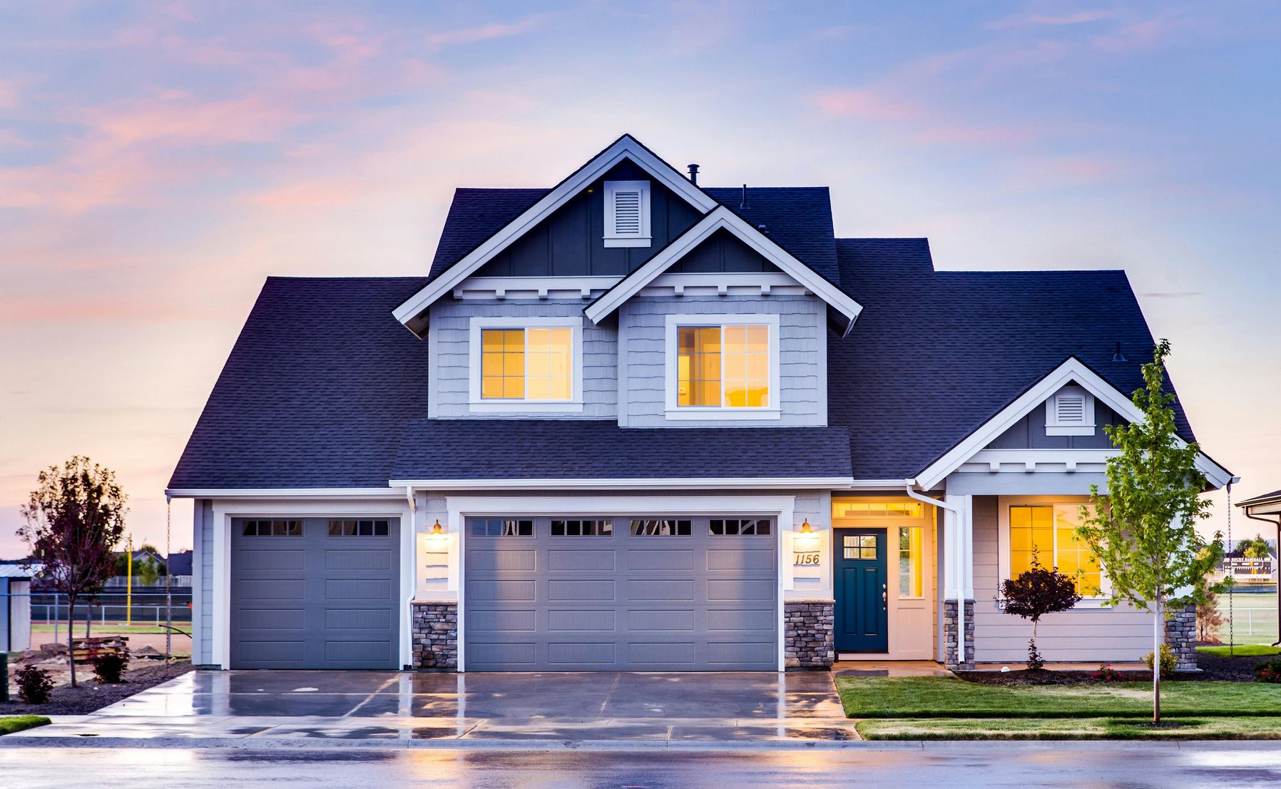 Two Aperol Spritz cocktails in wine glasses on a wooden table, orange hues, black straws, outdoors.