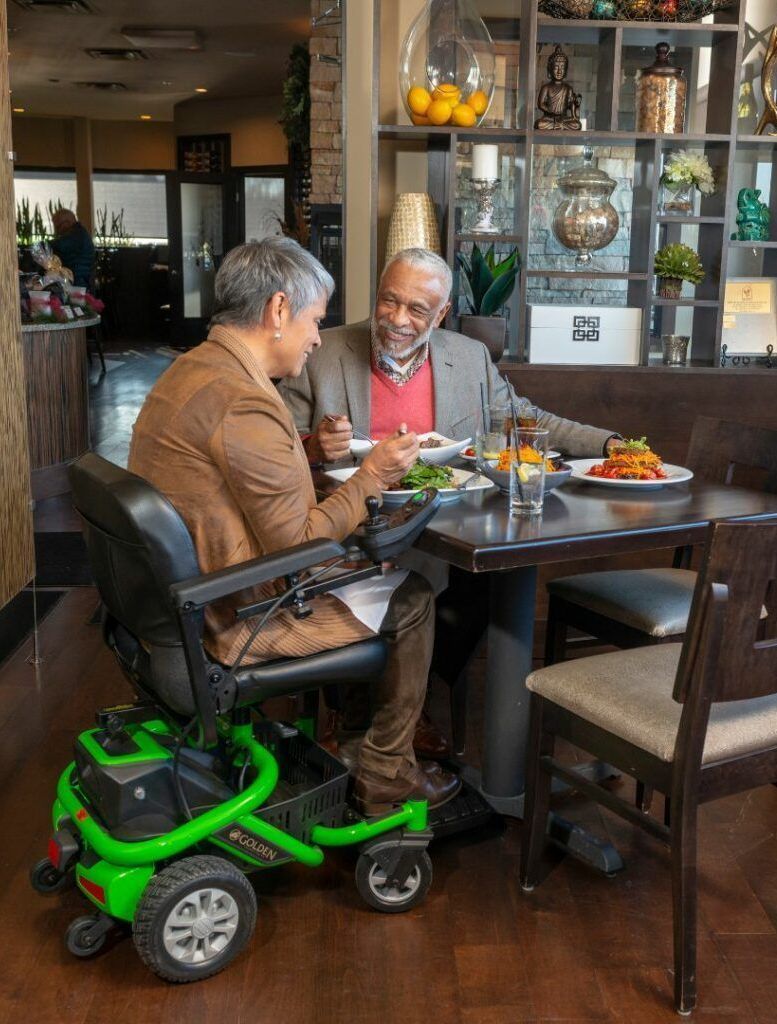 2 people eating, 1 in a power wheelchair