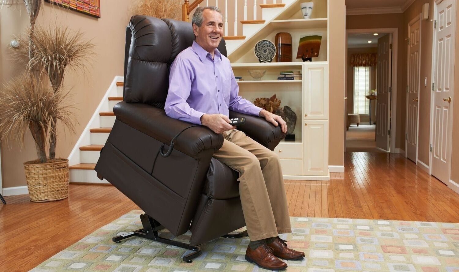 A man is sitting in a recliner in a living room.