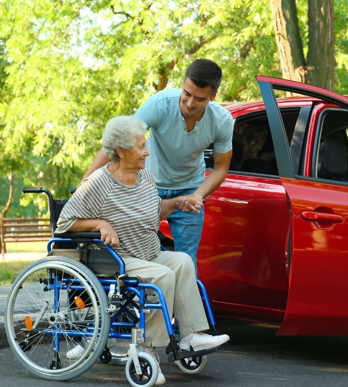 a woman in a wheelchair getting into a car