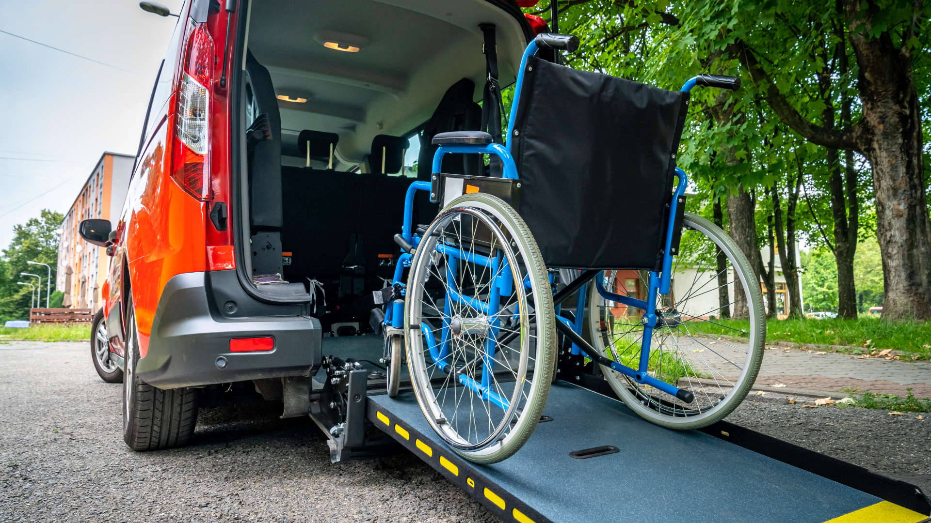 A wheelchair is being lifted into the back of a van.