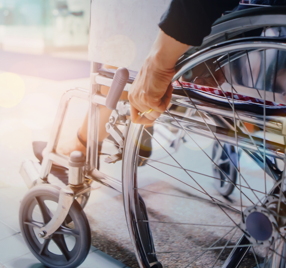 A person in a wheelchair with their hand on the wheel