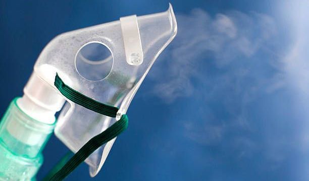 A close up of an oxygen mask with smoke coming out of it.