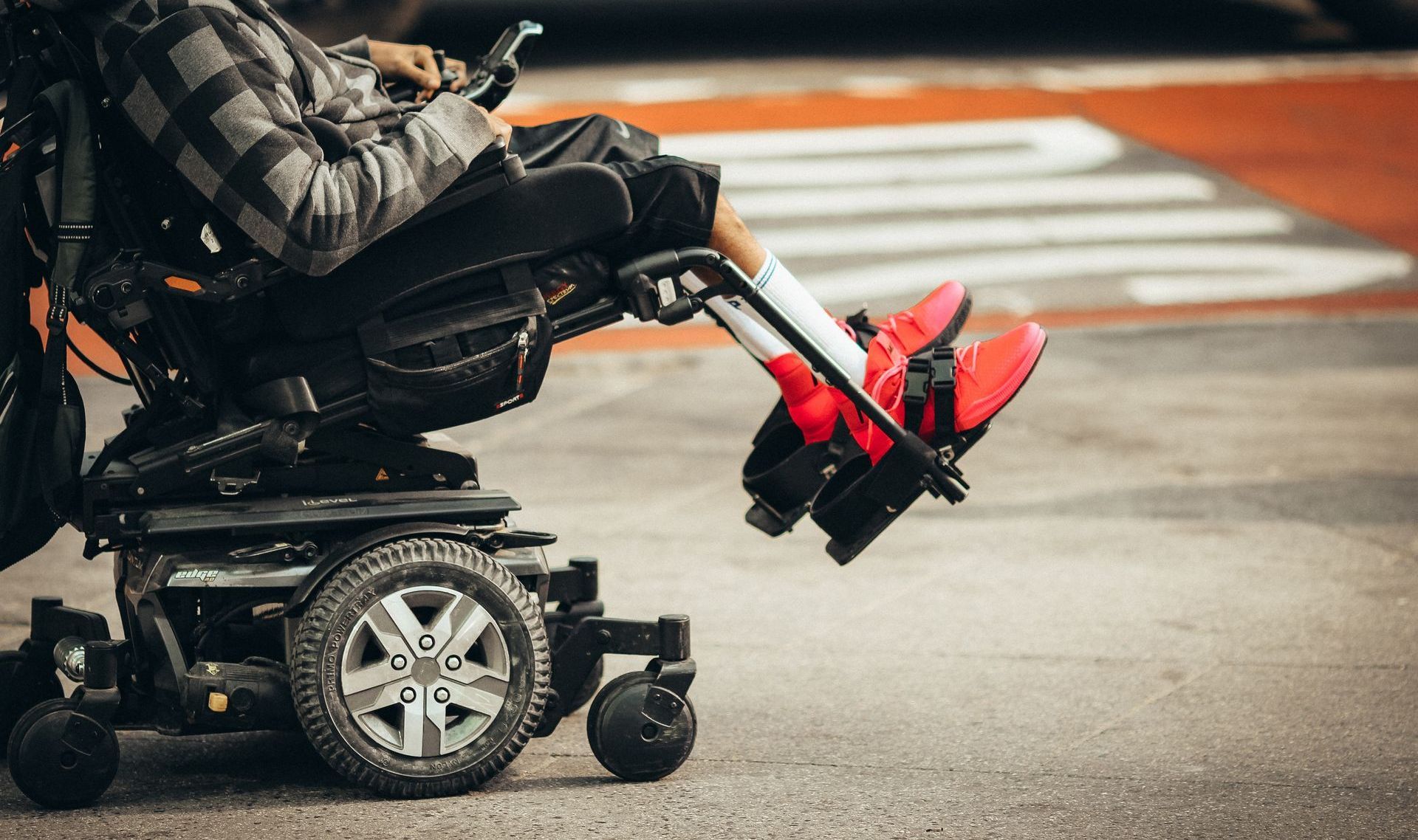 a man in a wheelchair is wearing red shoes