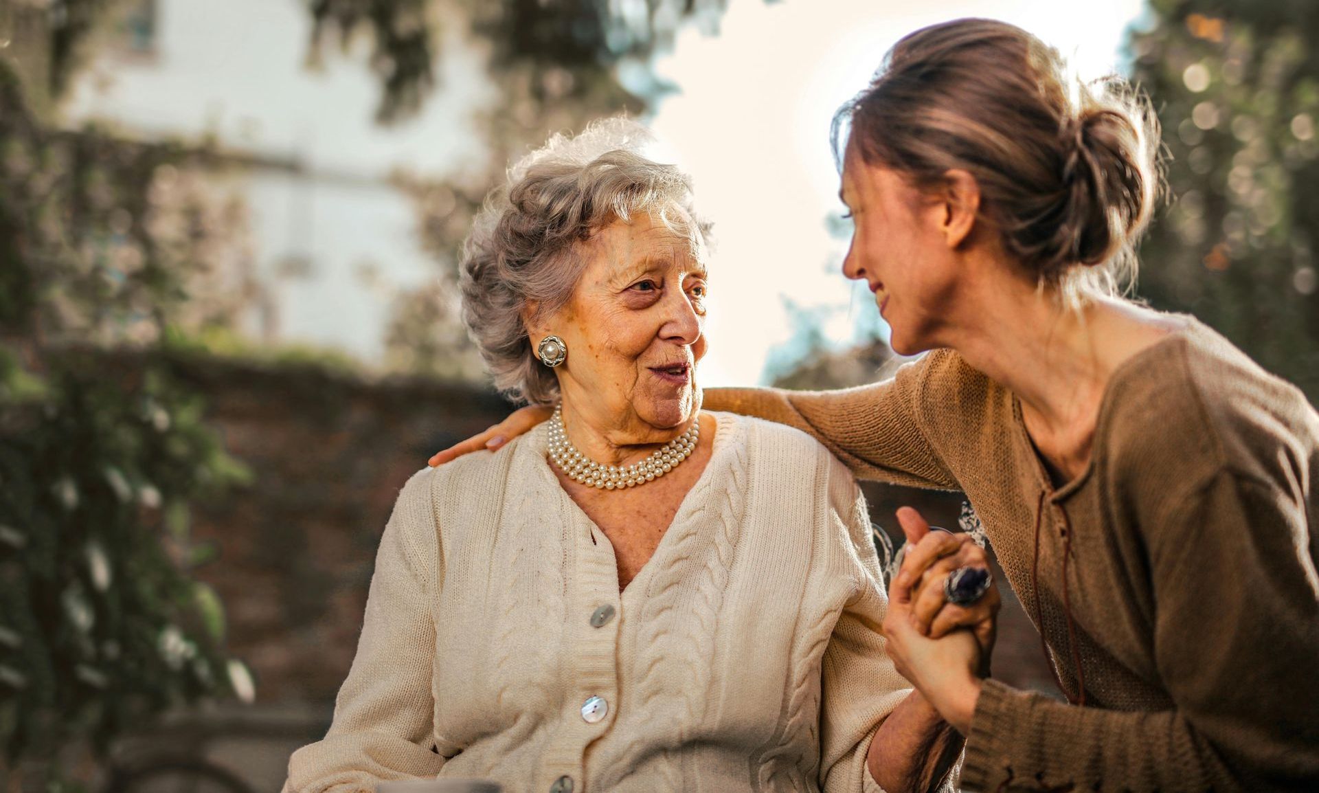 A woman is taking a picture of an elderly woman in a wheelchair.