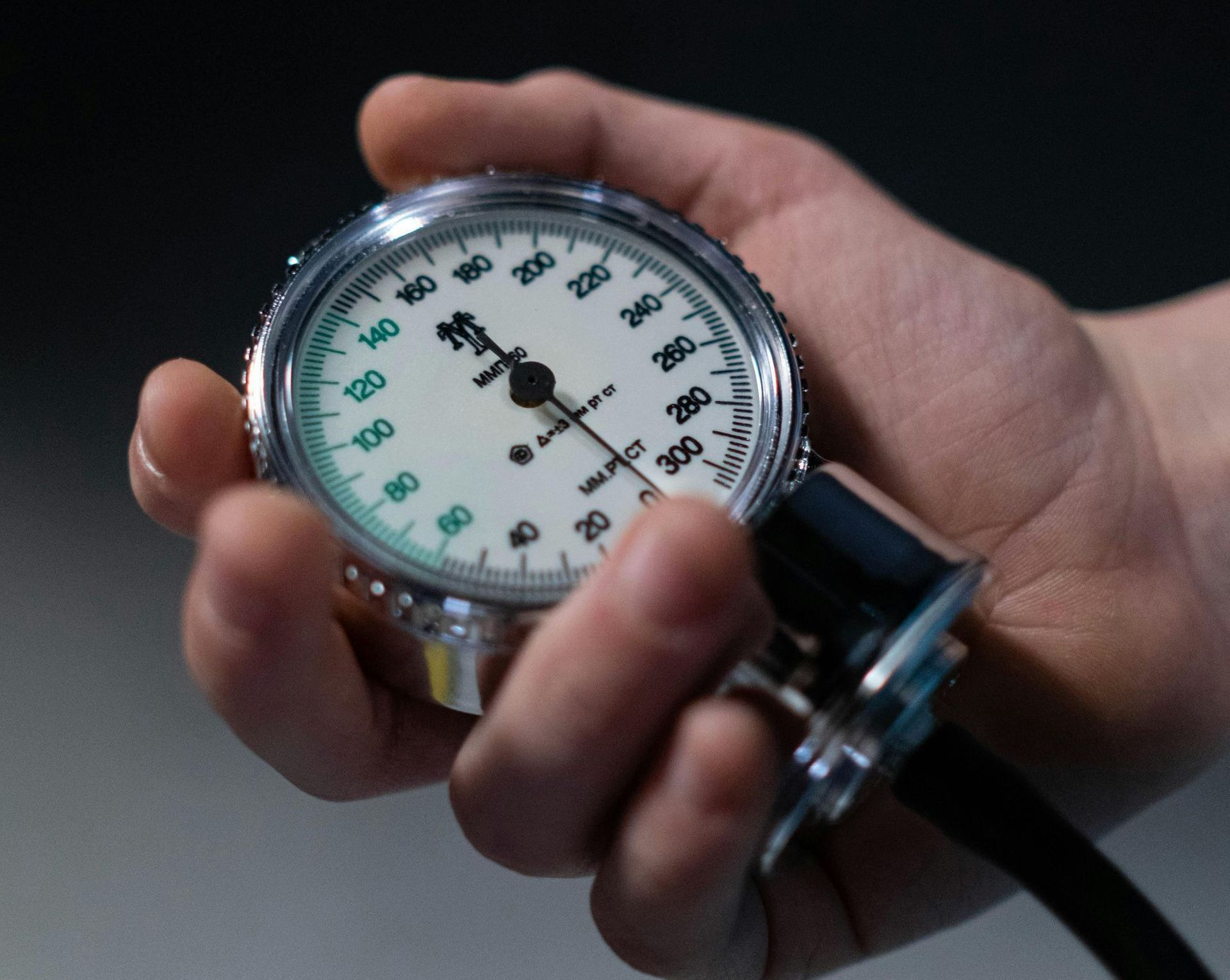 A person is holding a sphygmomanometer in their hand