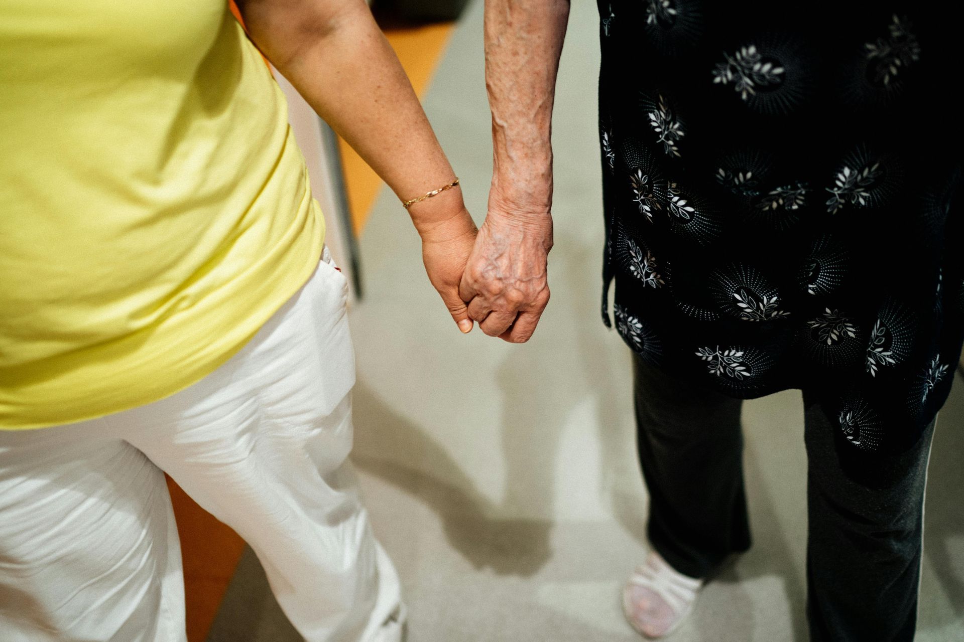 elderly couple holding hands