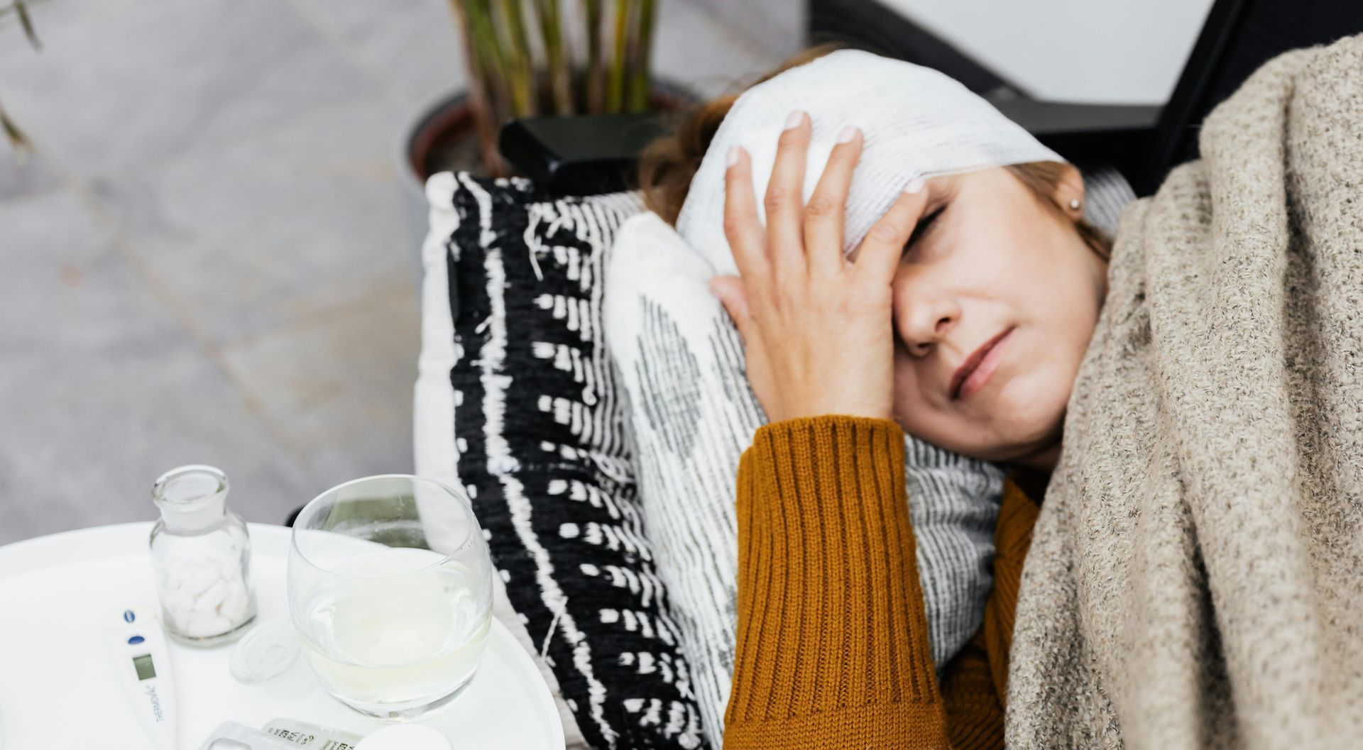 A woman is laying in bed with a bandage on her head.