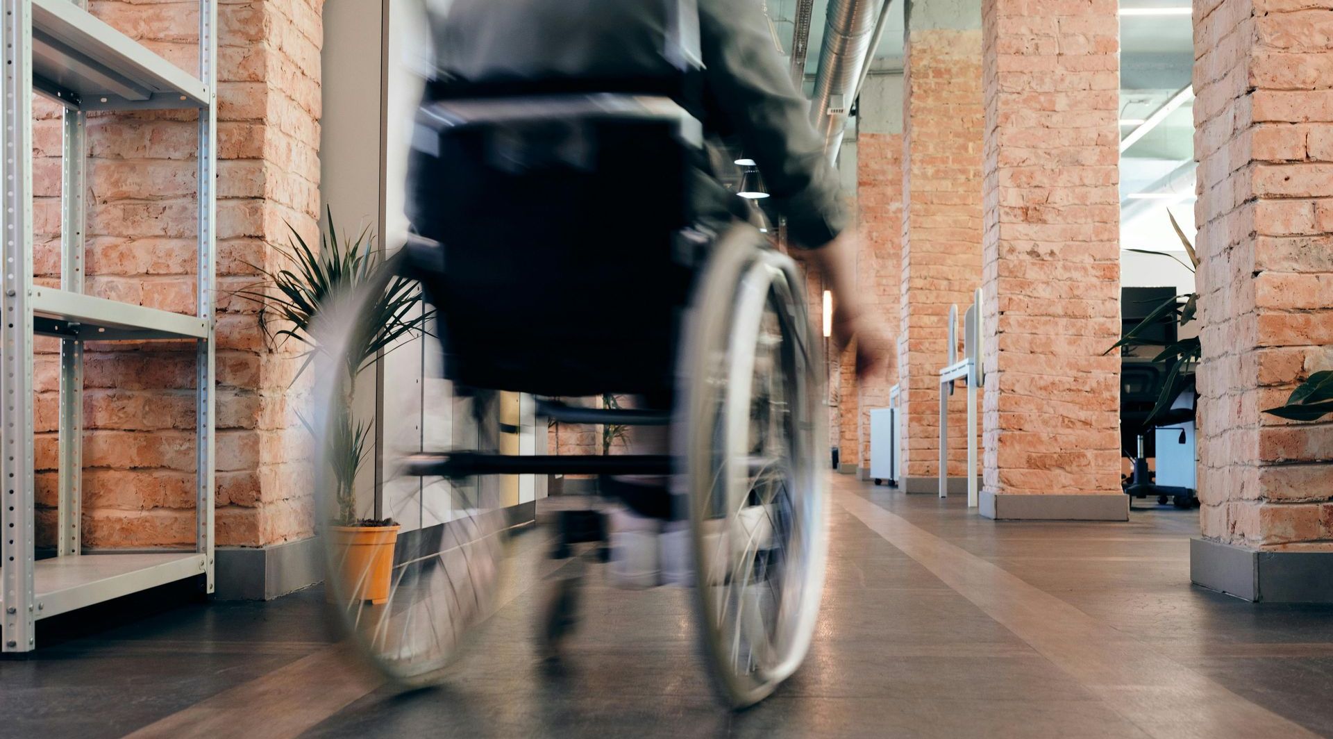 A person in a wheelchair is driving down a hallway.