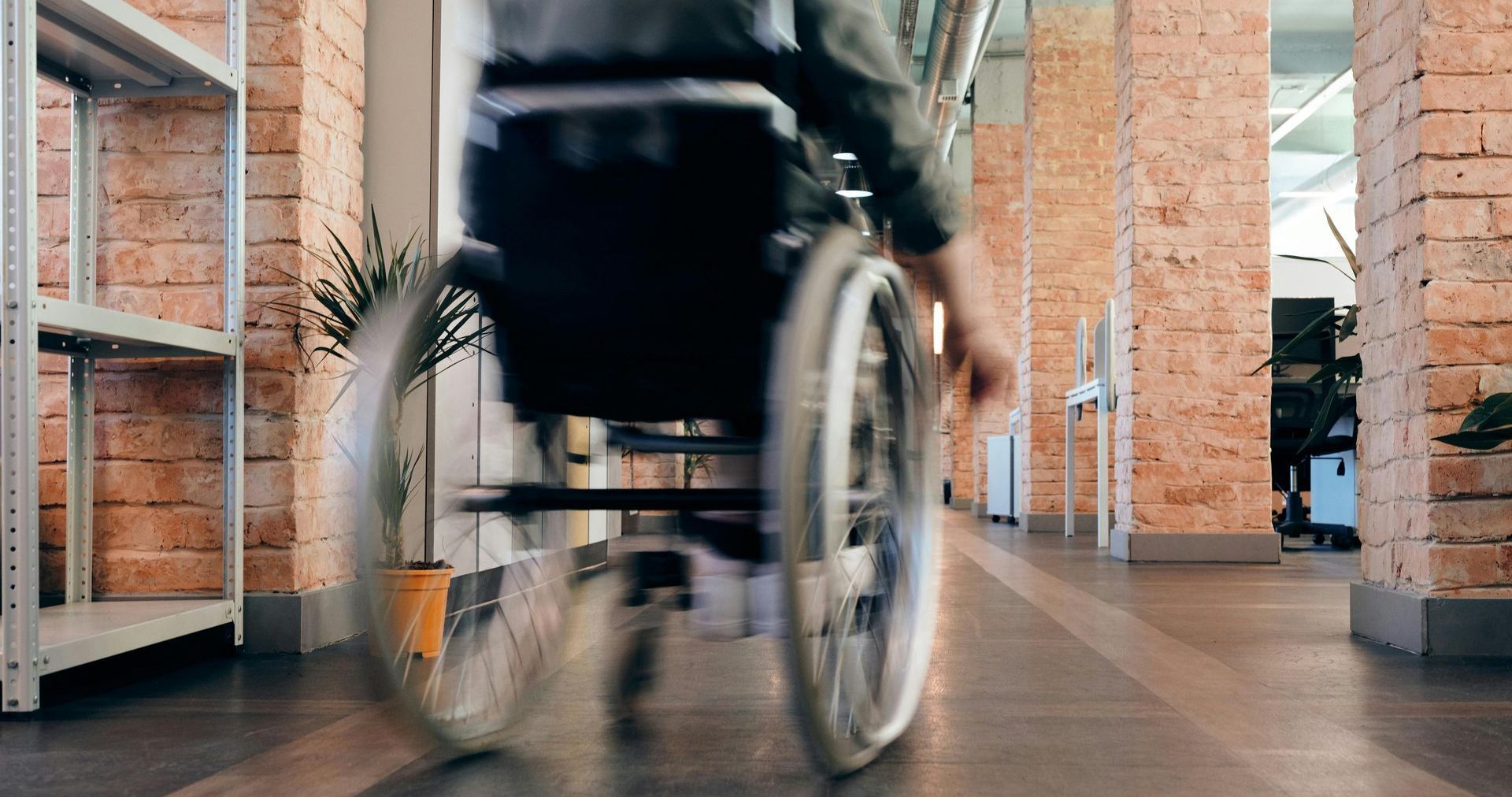 A person in a wheelchair is walking down a hallway.