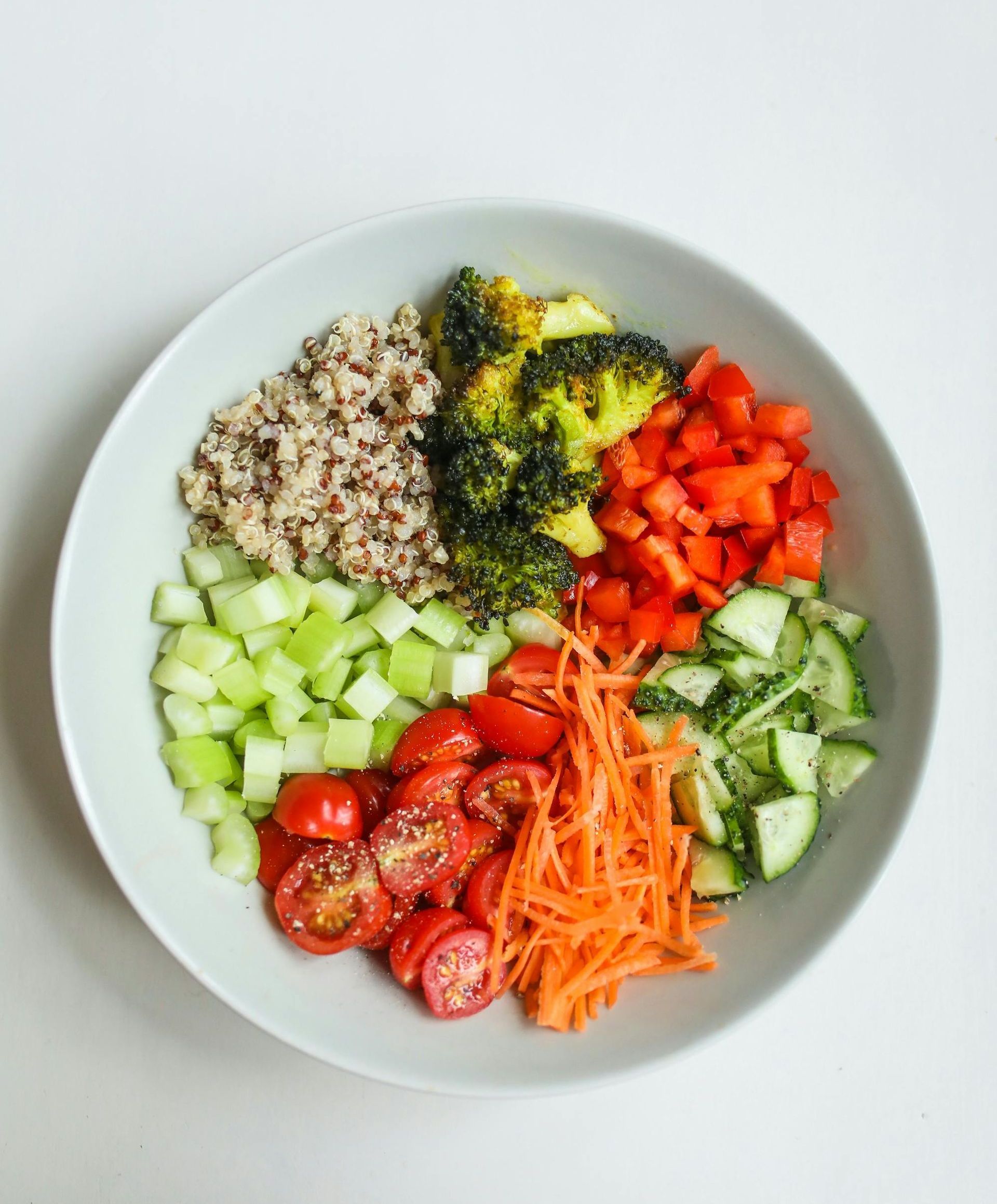 A bowl filled with vegetables and rice on a table.