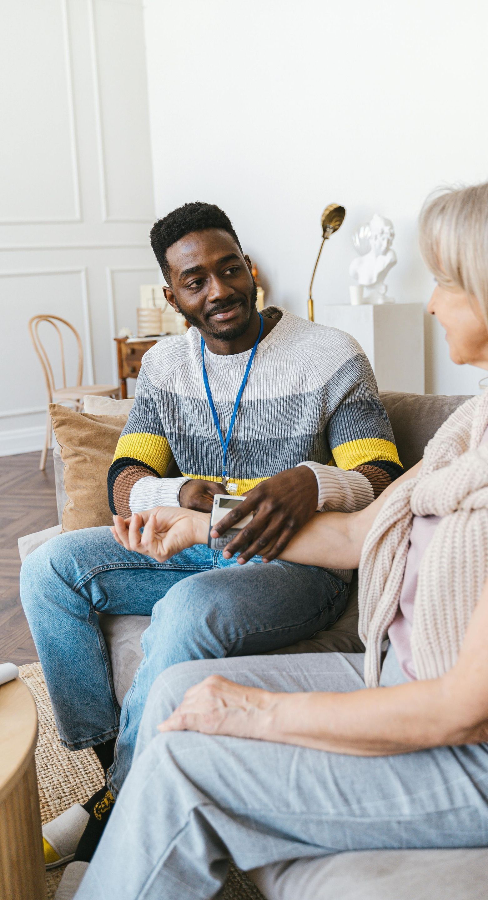 A man and a woman are sitting on a couch talking to each other.