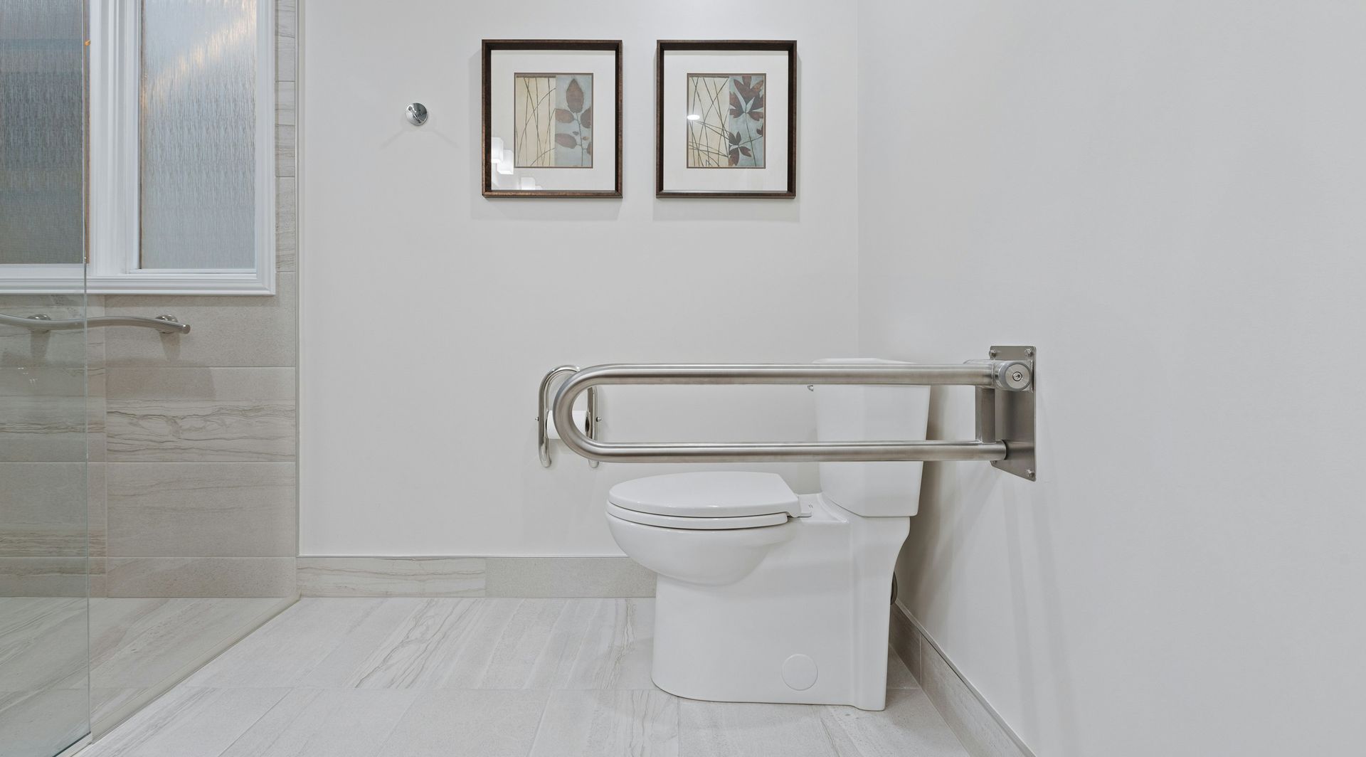 A bathroom with a toilet and a hand rail.