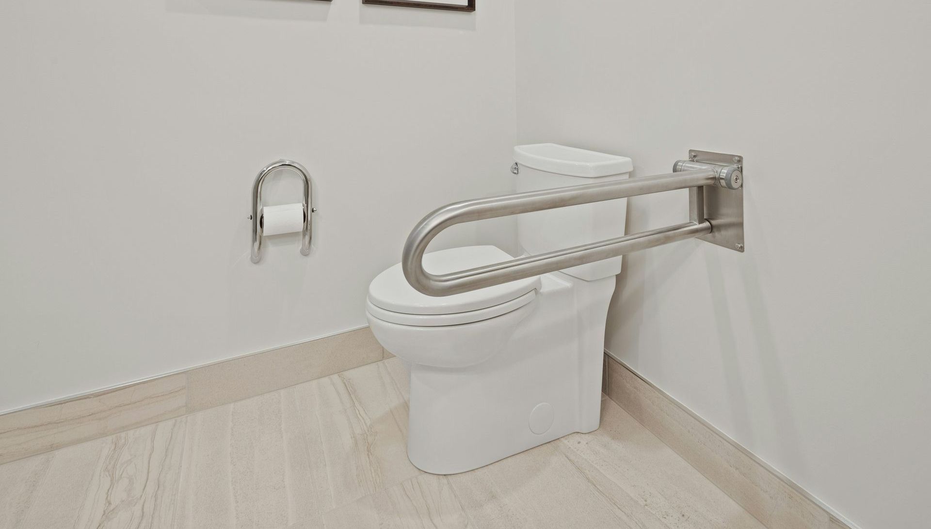A white toilet with a stainless steel handle is in a bathroom.