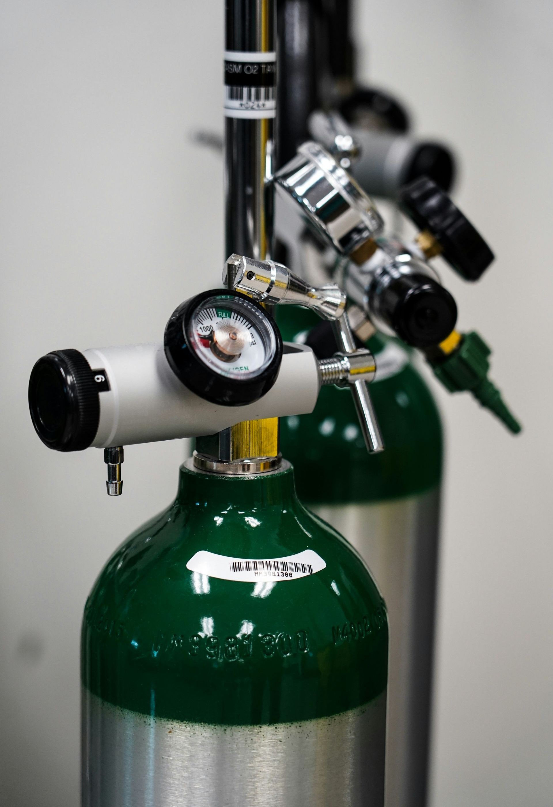 Two oxygen cylinders are sitting next to each other in a room.