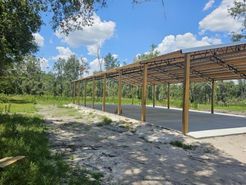 A large wooden structure is being built in the middle of a field.