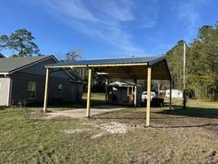A carport is being built in the backyard of a house.