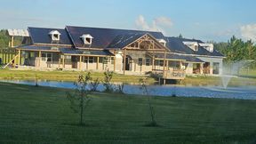 A large house is being built next to a pond.