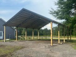 A carport is being built in the backyard of a house.
