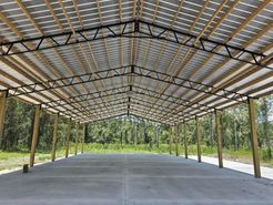 A large warehouse with a metal roof and wooden beams.