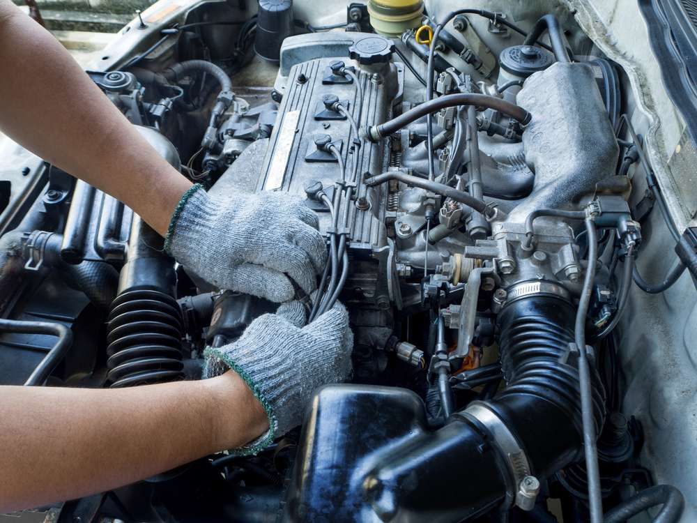 A Person Is Working On The Engine Of A Car — Baker Automotive In Bungalow, QLD