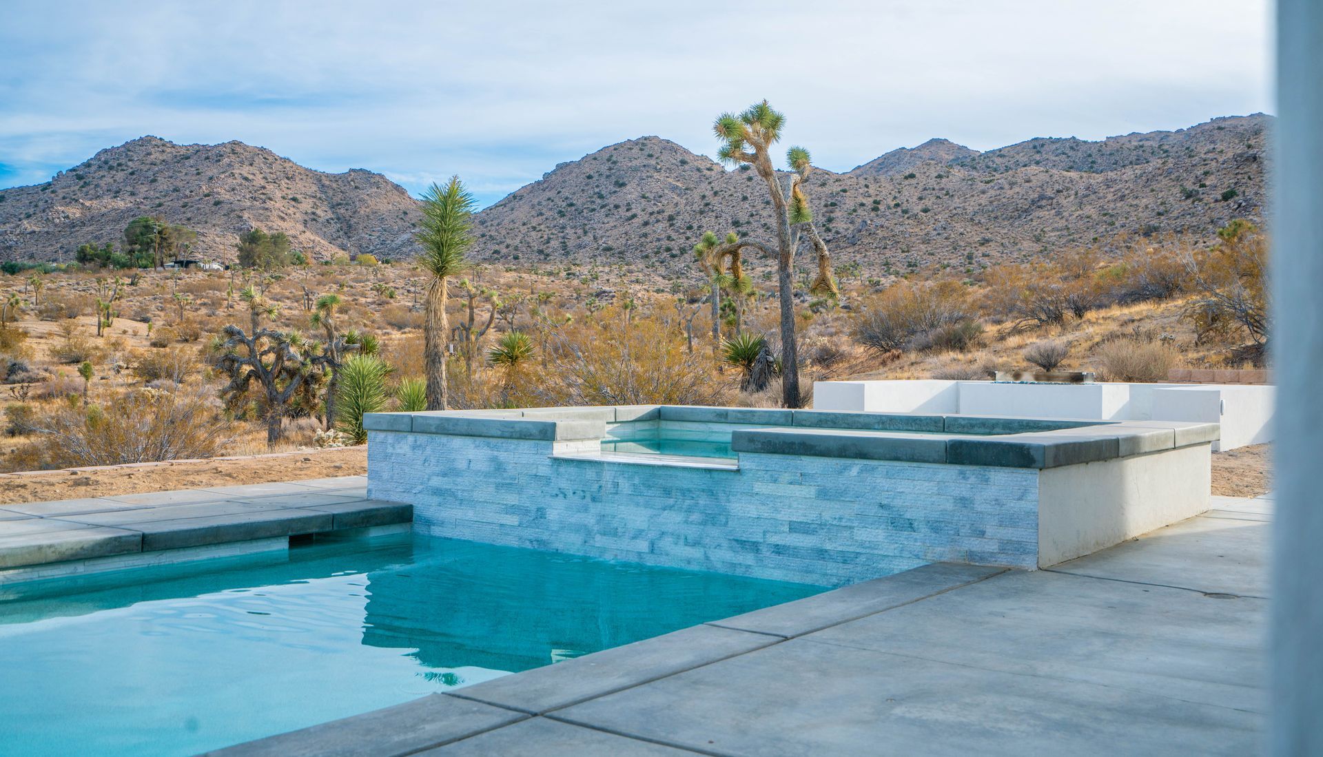 Swimming pool with mountain view in arid desert landscape.