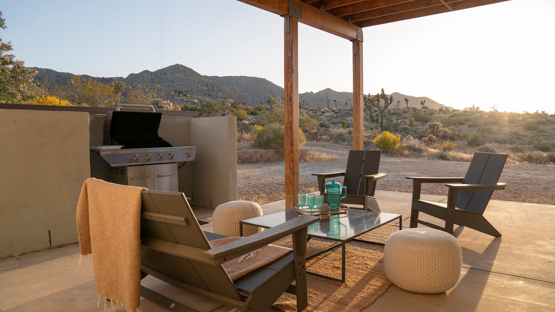 Patio with grill, seating, and desert mountain backdrop at sunset.