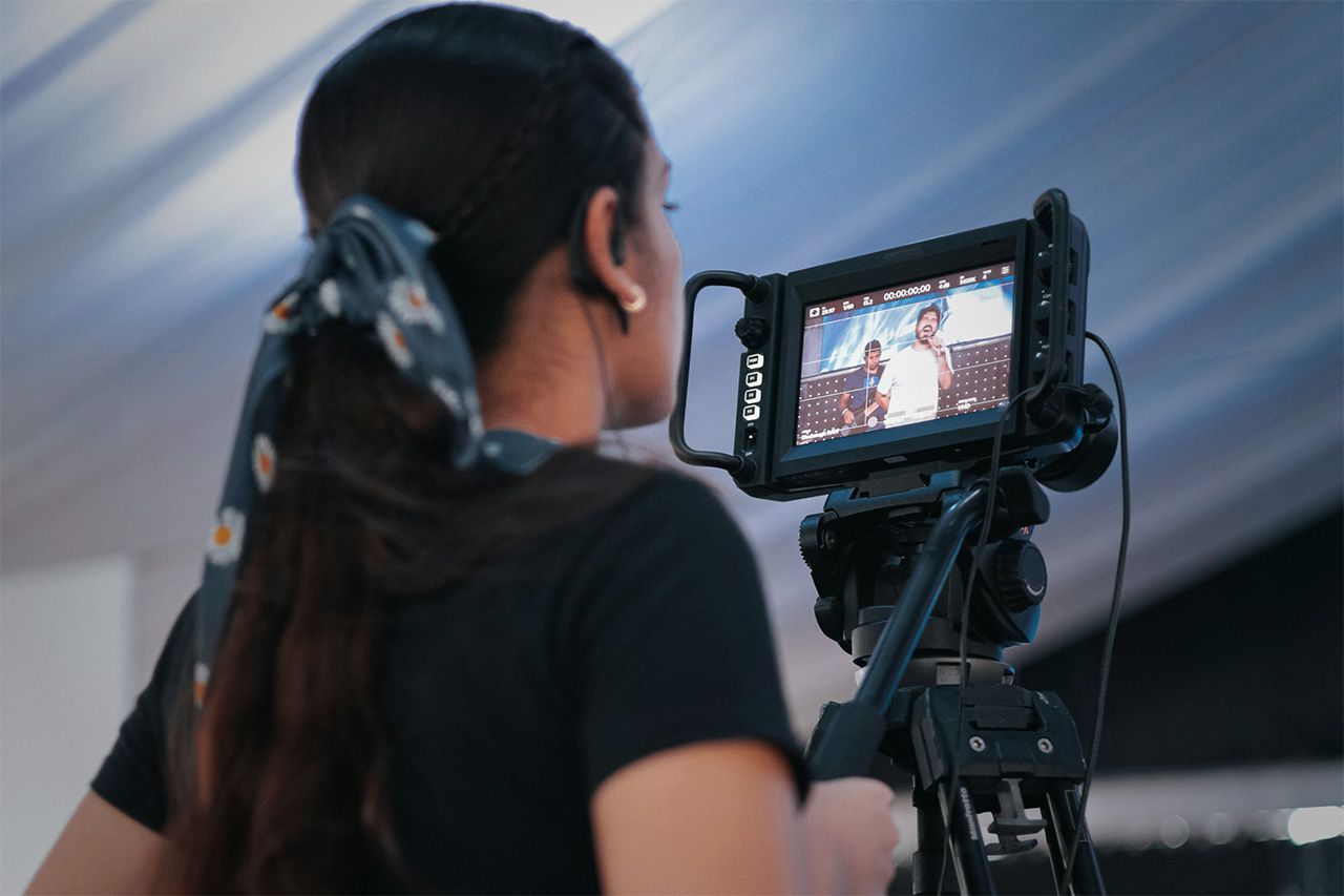 A woman behind the lens on a video production shoot.