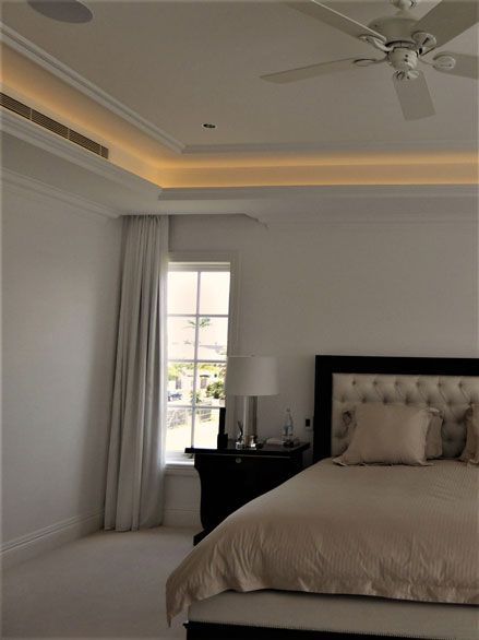 Bedroom with brown bedsheet — Manufacturing Cornices in Logan Village, QLD
