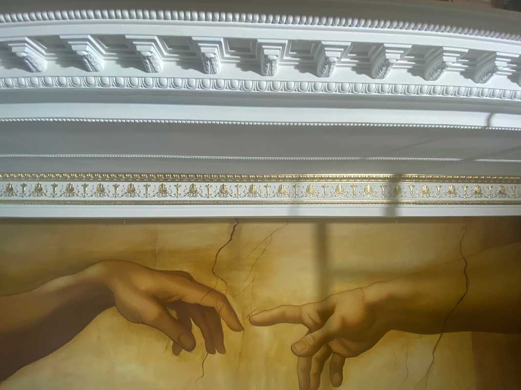 Pointy finger connecting painted on wall — Manufacturing Cornices in Logan Village, QLD