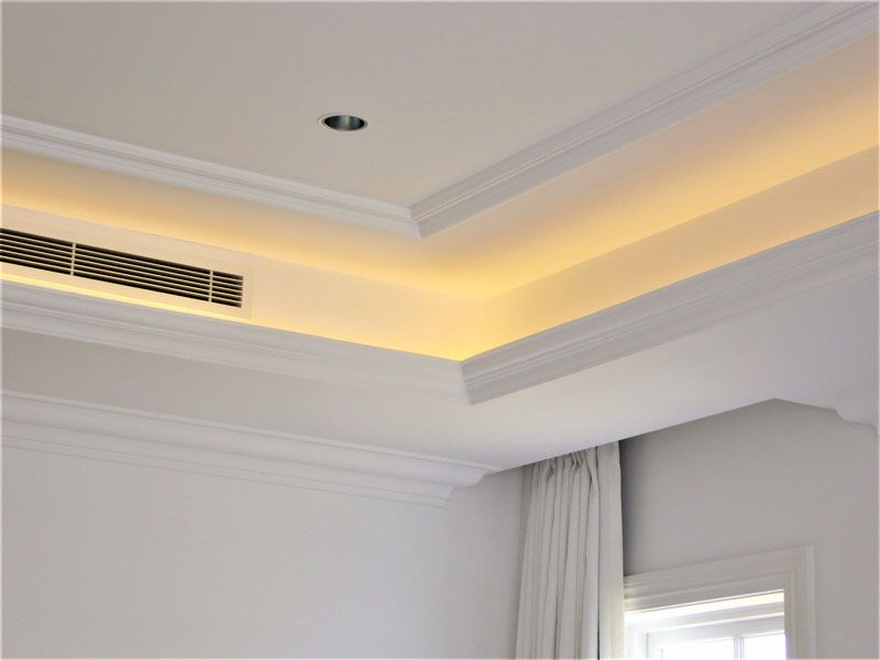 A bedroom with a ceiling fan and a window.