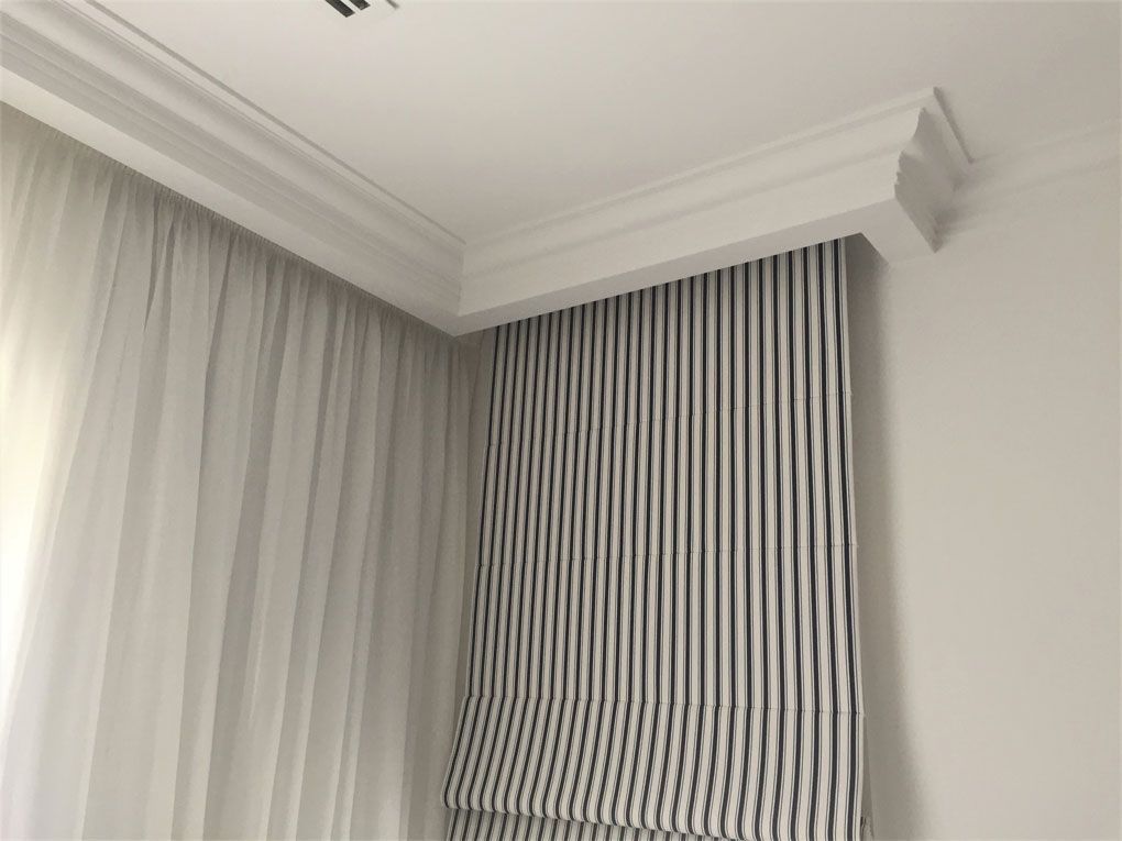 A room with white curtains and a black and white striped curtain