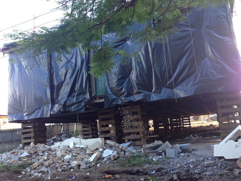House with plastic bags around — Manufacturing Cornices in Logan Village, QLD