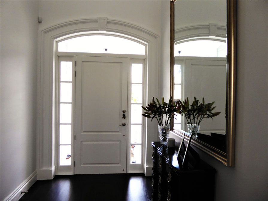 A hallway with a white door and a mirror