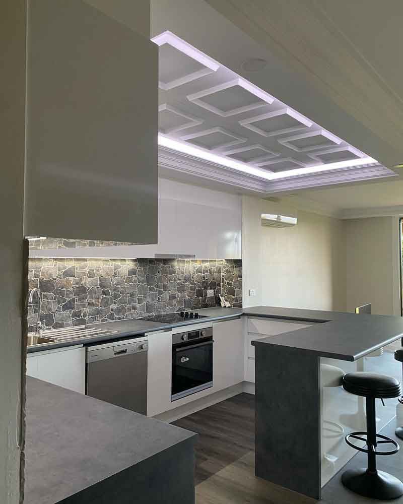 Kitchen with white light and black chair — Manufacturing Cornices in Logan Village, QLD