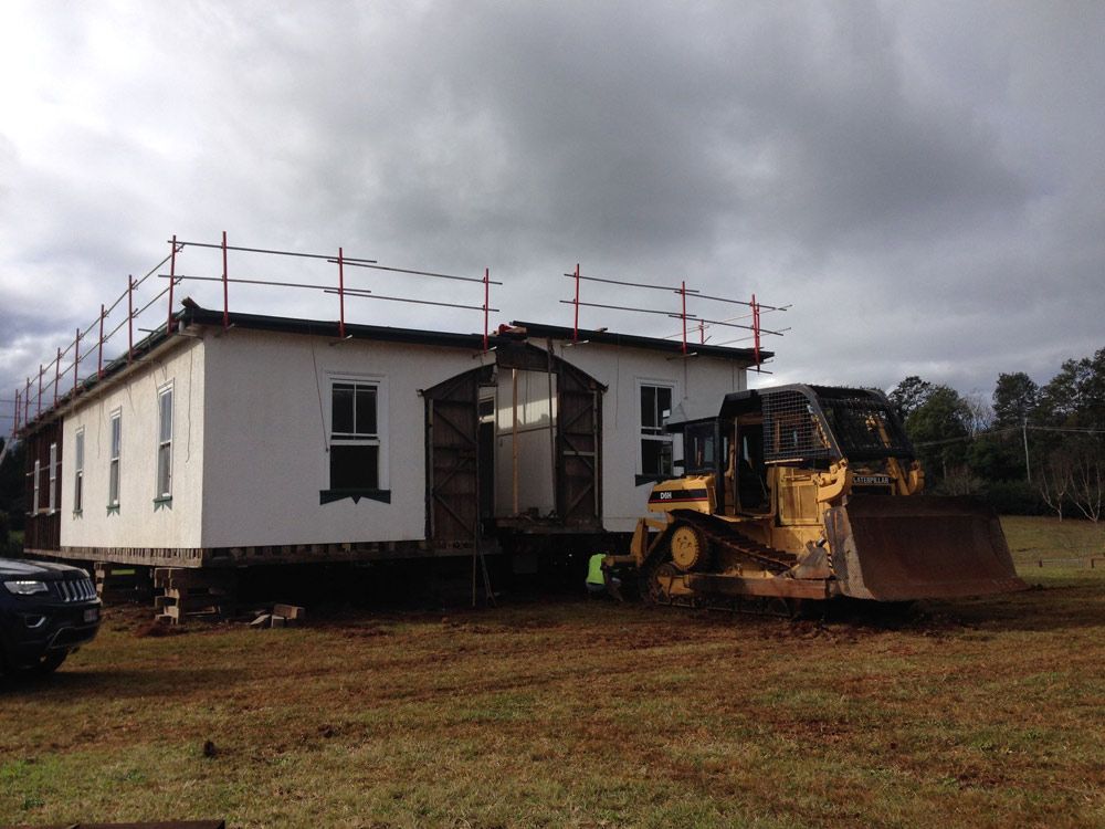 House with bulldozer— Manufacturing Cornices in Logan Village, QLD