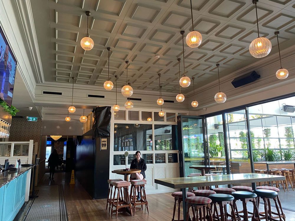 A woman is sitting at a table in a restaurant.