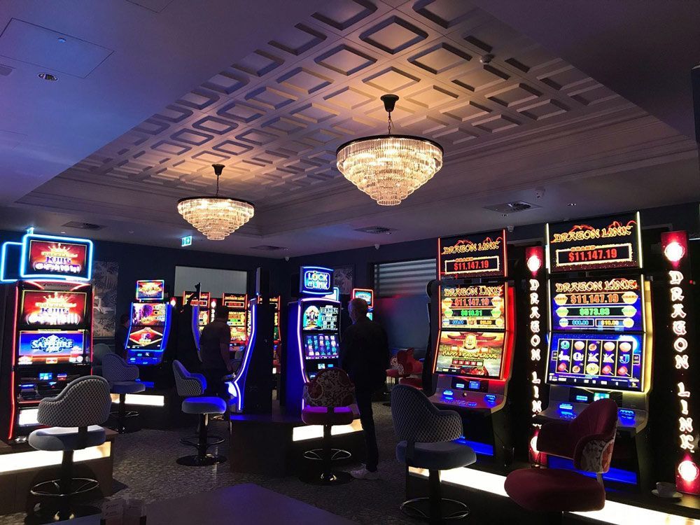 People are playing slot machines in a casino with a sign that says reebok
