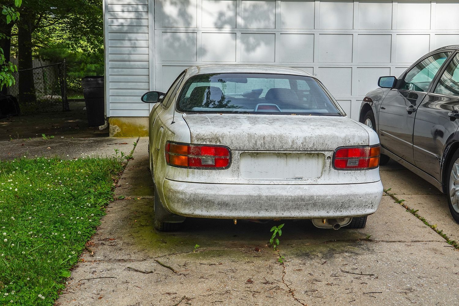 A junk car in front of a porch. A junk car in front of a porch.